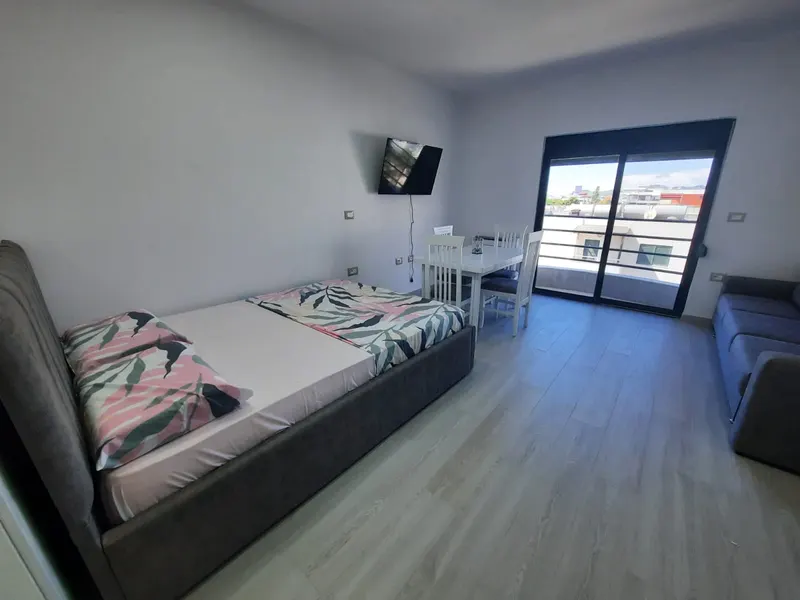 Double bed and balcony door in the studio apartment