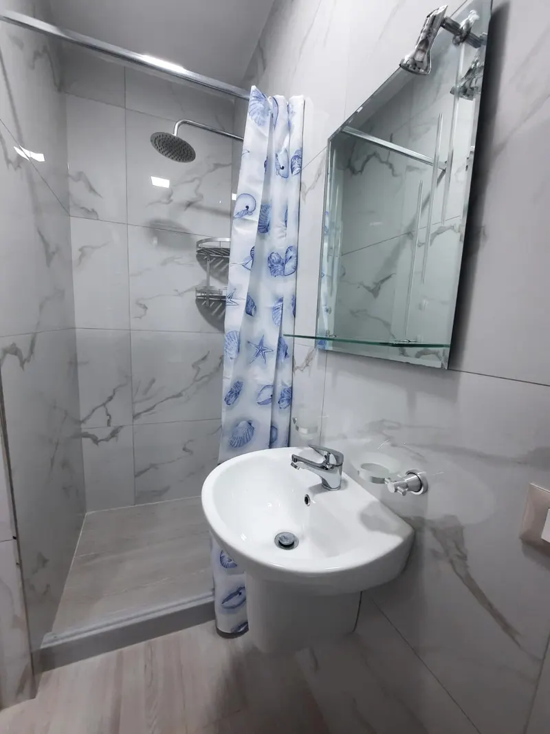 Bathroom with walk-in shower and marble-style tiles